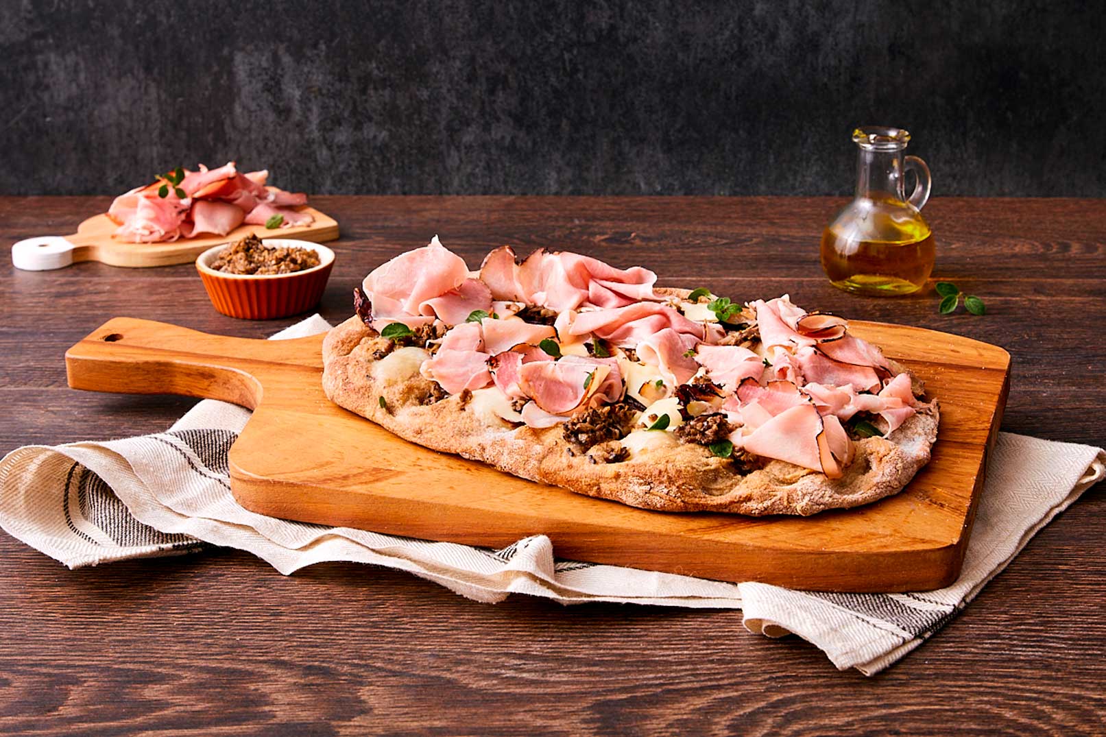 Pinsa integrale con prosciutto arrosto, mozzarella, crema al tartufo, radicchio e maggiorana