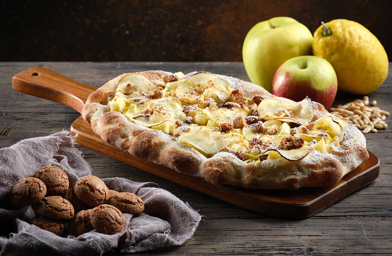 Pinsa con impasto di Strudel e topping di mele, zucchero di canna, zucchero a velo, zeste di limone e amaretti