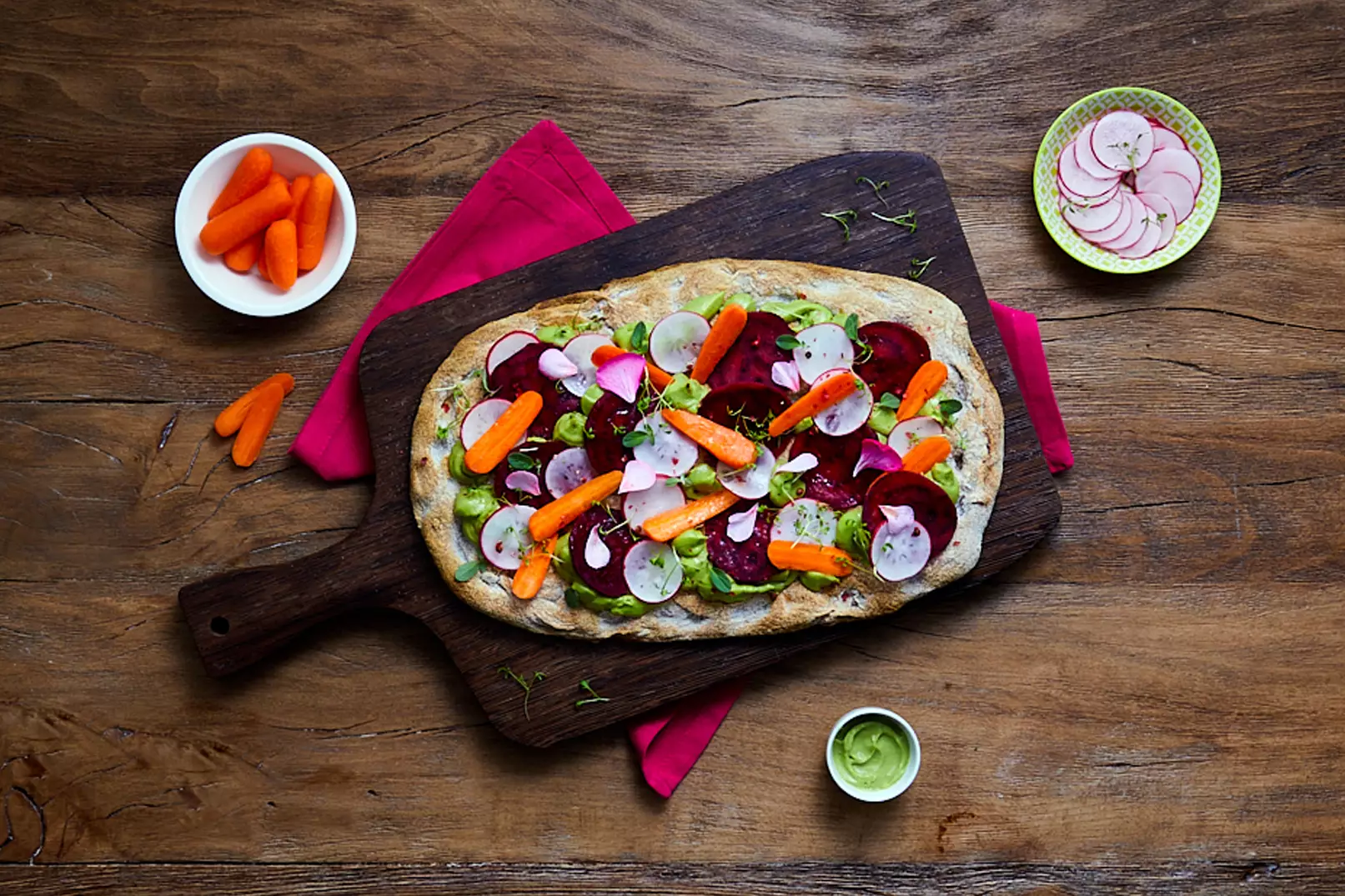 Pinsa con avocado, limone, verdure miste, germogli in foglia, maggiorana, fiori vari e pepe rosa