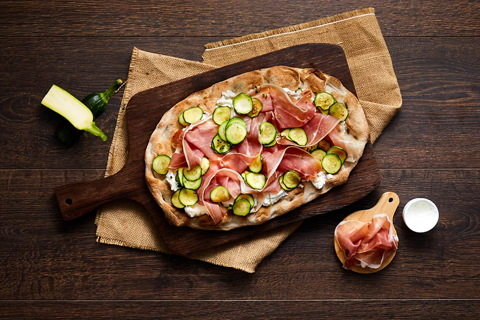 Pinsa con prosciutto crudo, zucchine a rondelle e formaggio spalmabile