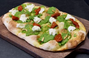 pinsa con pesto di rucola, pomodorini secchi e mozzarella 