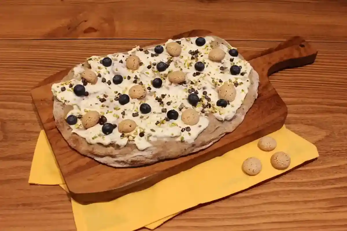 Pinsa con mascarpone, amaretti, mirtilli, cioccolato e granella di pistacchio