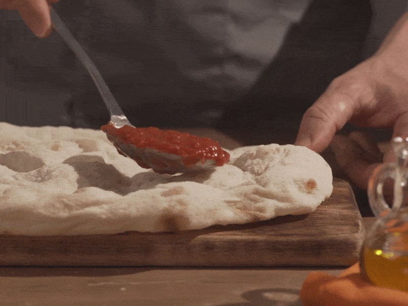 2. FarcisciOra che il forno è caldo e ha raggiunto la temperatura, condisci la Pinsa con gli ingredienti "base”, come pomodoro e mozzarella. Ti consigliamo di aggiungere gli ultimi ingredienti, come salumi e formaggi, fuori forno: così otterrai un risultato semplicemente perfetto!