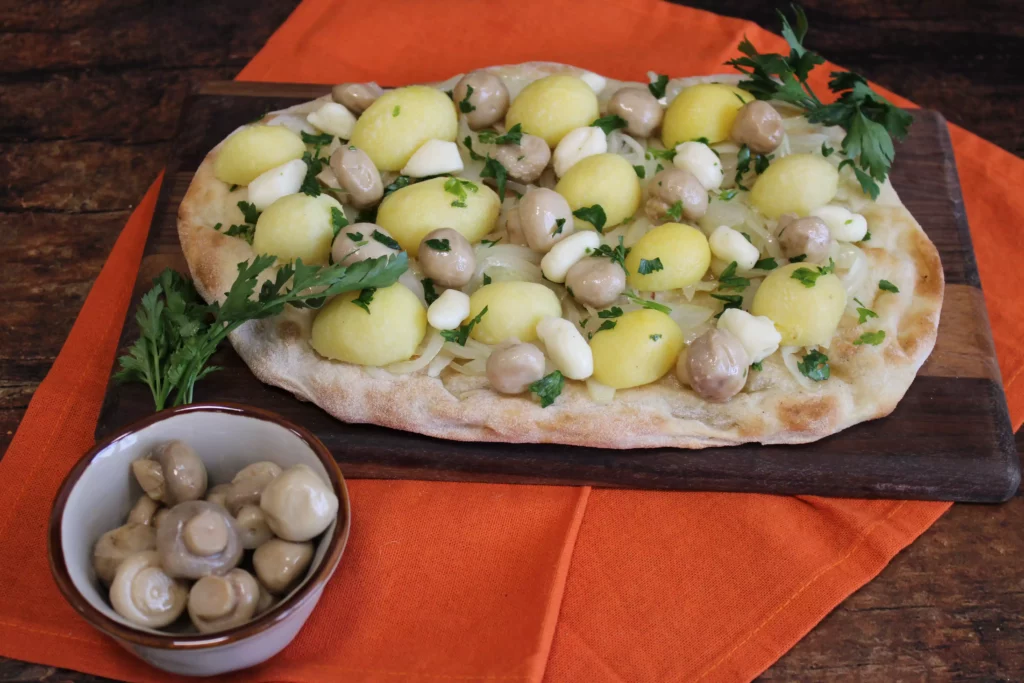 Pinsa con funghi champignon, cipolla, patate novelle e prezzemolo