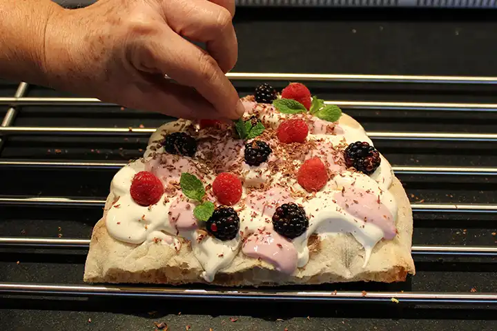 Guarnisci con frutti di bosco, cioccolato e menta