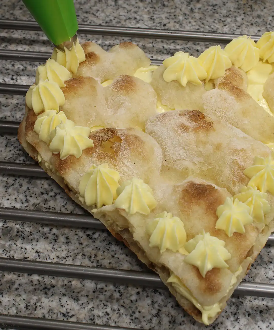 Decke sie ab und dekoriere sie mit Mascarpone-Creme-Tuffs, Erdbeeren, Puderzucker und Minzblättern