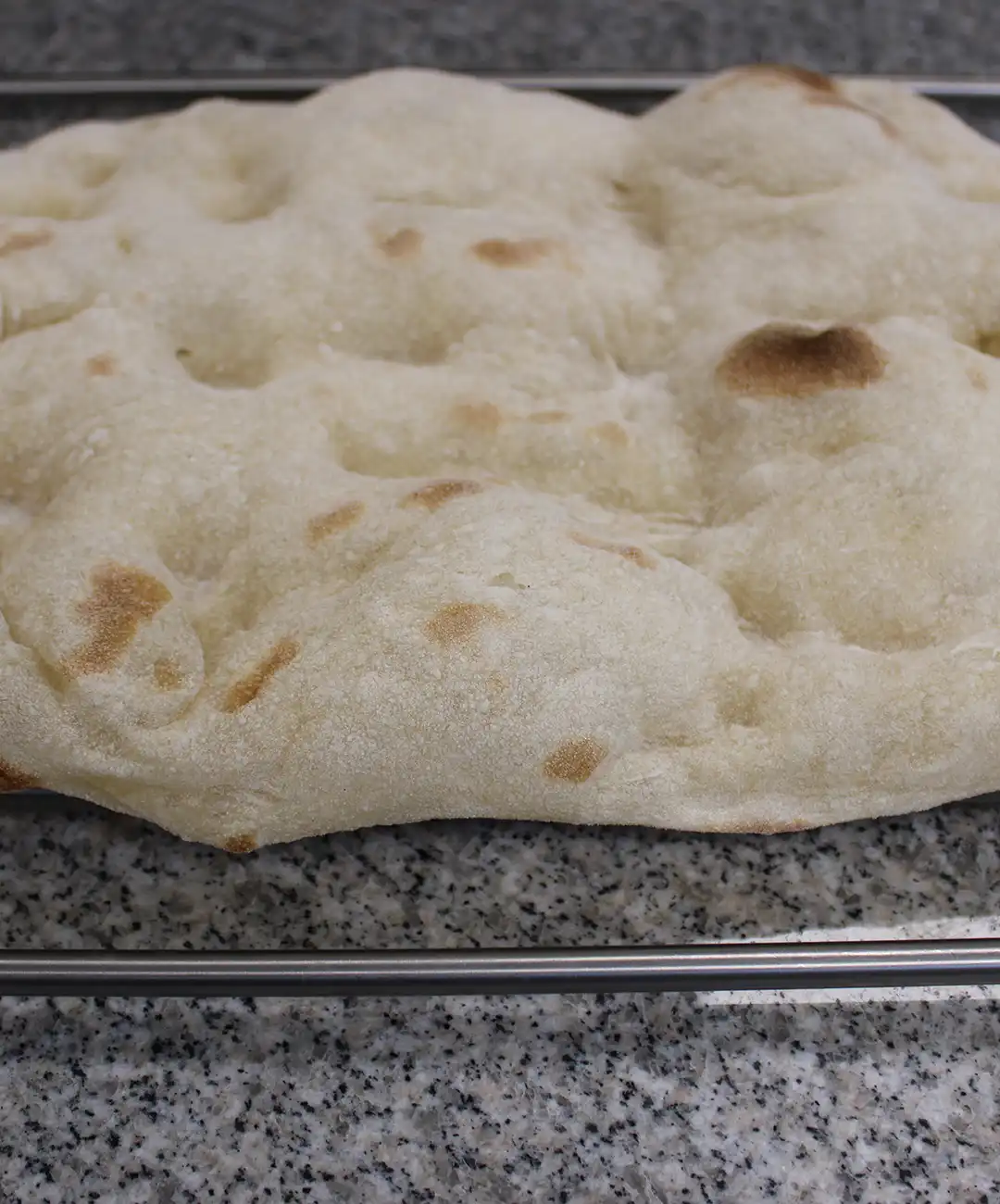 Lege den Pinsa-Boden auf ein Backblech.