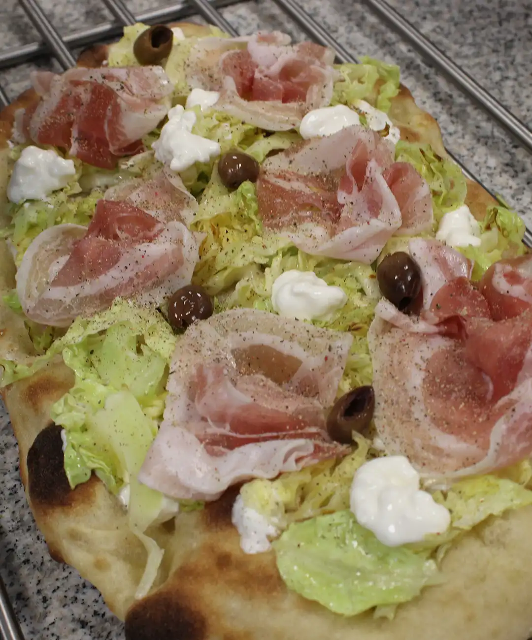 Füge die Taggiasca Oliven und den Mozzarella hinzu