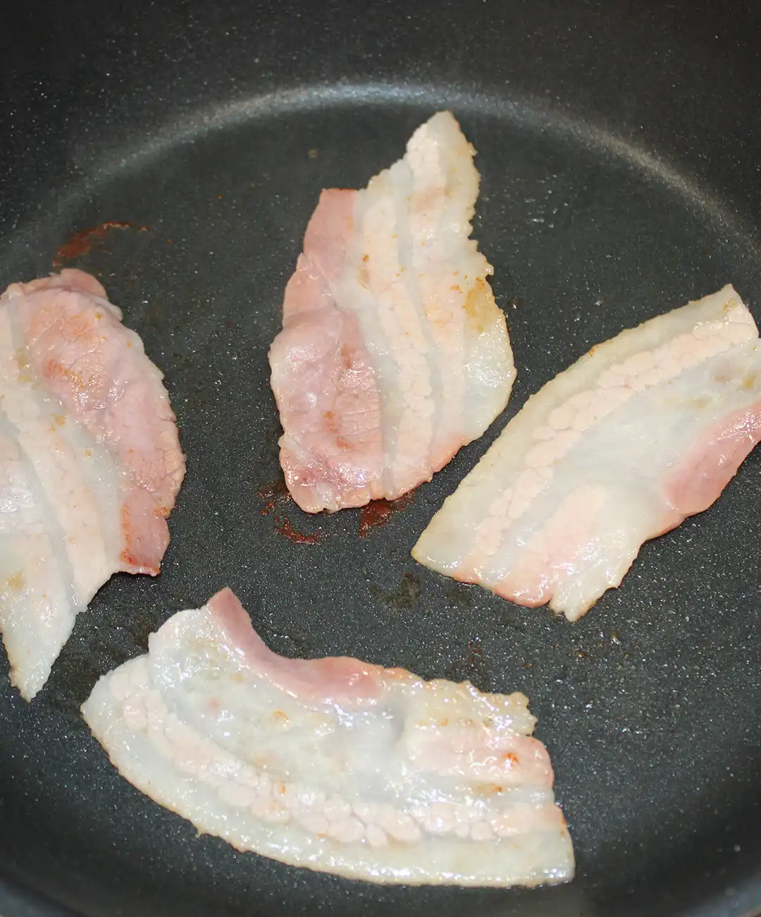 In una padella riscaldata, fai cuocere la pancetta fino a renderla croccante