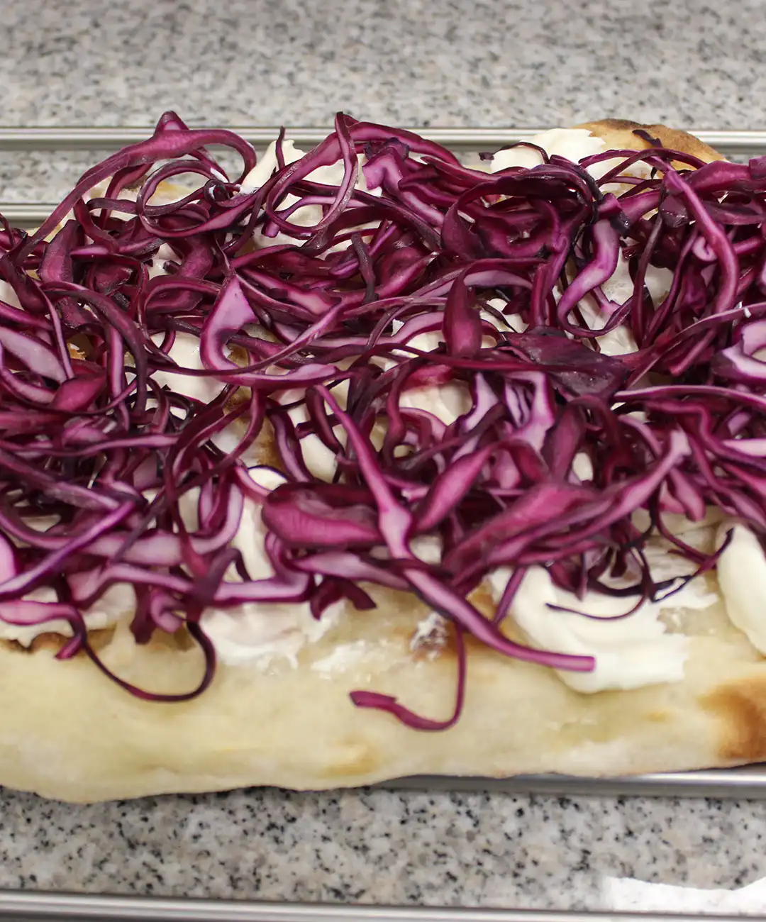 Ricopri la base con formaggio spalmabile e cavolo viola