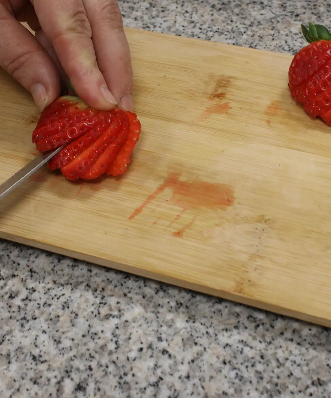 Schneide die Erdbeeren und bereite die Mascarpone-Creme zu