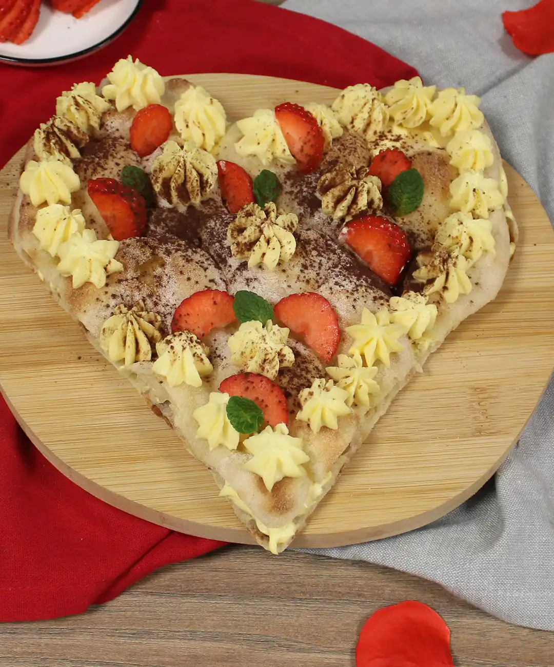 dekoriere mit Mascarpone-Creme-Tuffs, Erdbeeren, Puderzucker, Minzblättern und Kakao