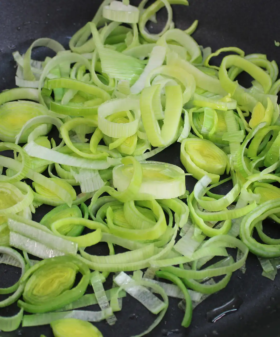 Taglia il porro e versalo in padella con olio, sale e pepe