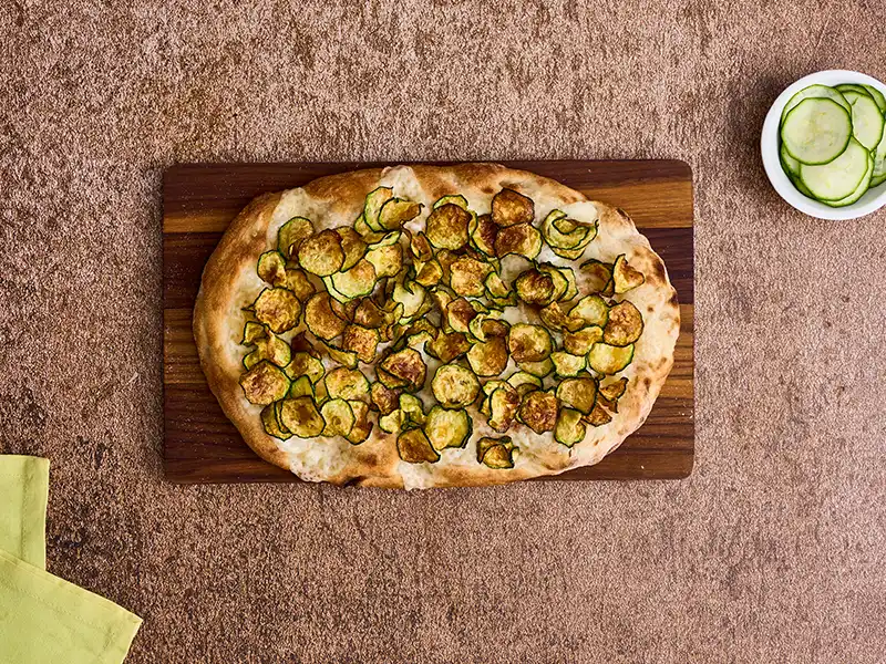 Disponi le zucchine fritte sulla base pinsa