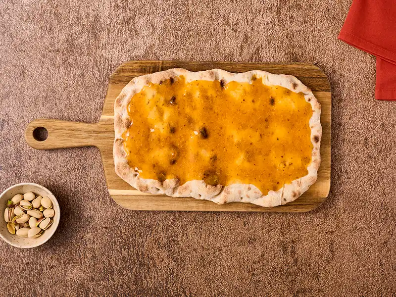 Stendi la crema di cachi sulla base pinsa